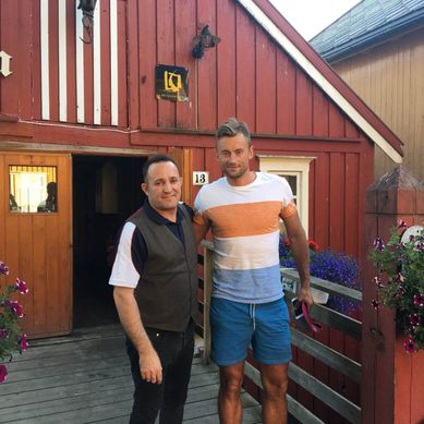 To menn (restauranteier og Petter Northug) som smiler til kamera