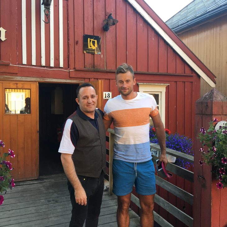To menn (restauranteier og Petter Northug) som smiler til kamera